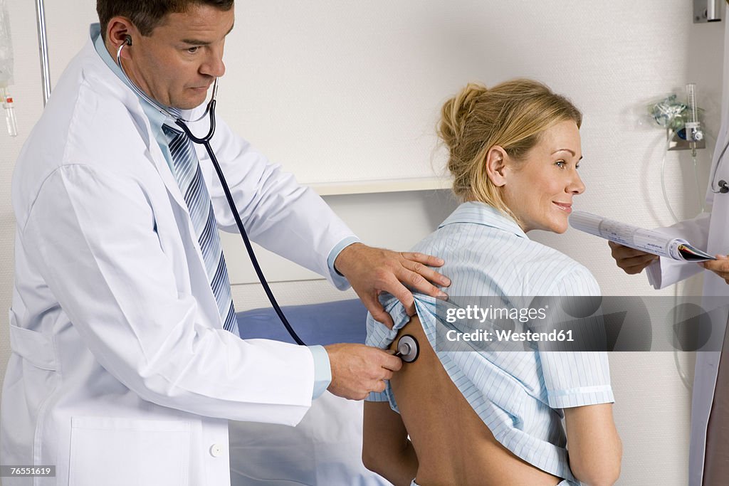 Doctor auscultating female patient