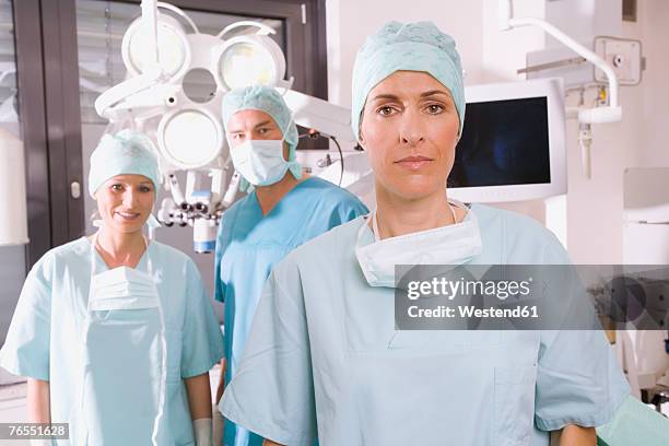 surgery team in operating room - chirurgenkappe stock-fotos und bilder