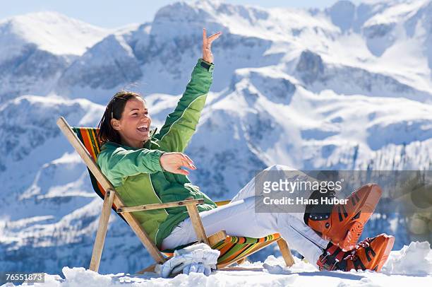 woman in mountains sitting in deck chair - ski boot stock pictures, royalty-free photos & images