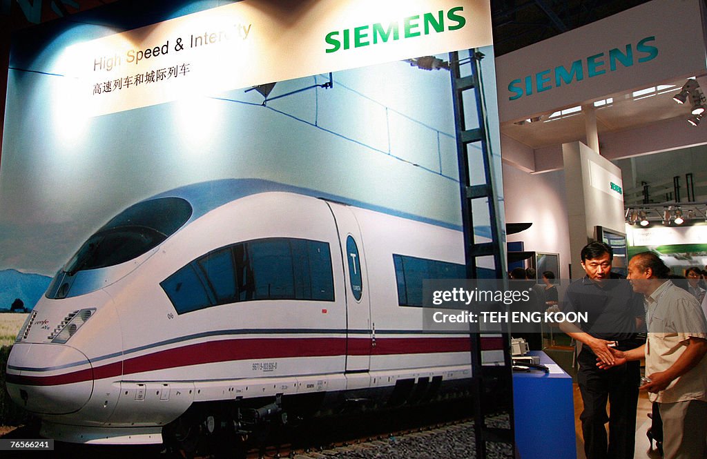 Chinese visitors look at a Siemens booth