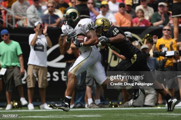 Kory Sperry of the Colorado State Rams carries the ball against Brad Jones of the Colorado Buffaloes at INVESCO Field at Mile High on September 1,...