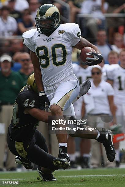 Kory Sperry of the Colorado State Rams carries the ball against Jordon Dizon of the Colorado Buffaloes at INVESCO Field at Mile High on September 1,...