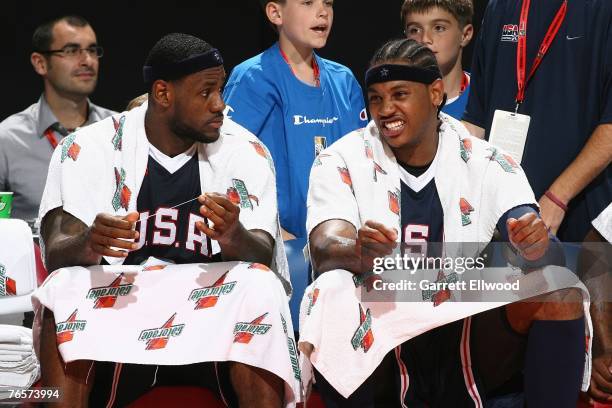 LeBron James and Carmelo Anthony of the USA Men's Senior National Team talk on the bench during a game in the preliminary round of the 2007 FIBA...