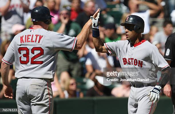 Julio Lugo of the Boston Red Sox high fives teammate Bobby Kielty during the MLB game against the Chicago White Sox on August 26, 2007 at U.S....