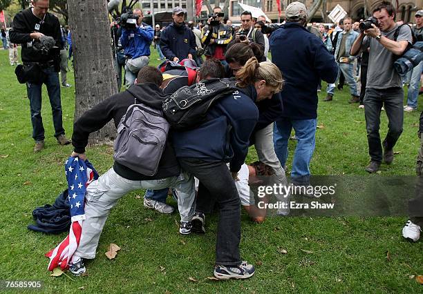 Undercover police hold down demonstrator who was attempting to burn the American flag during a 'Stop Bush - Make Howard History Rally' held at Sydney...