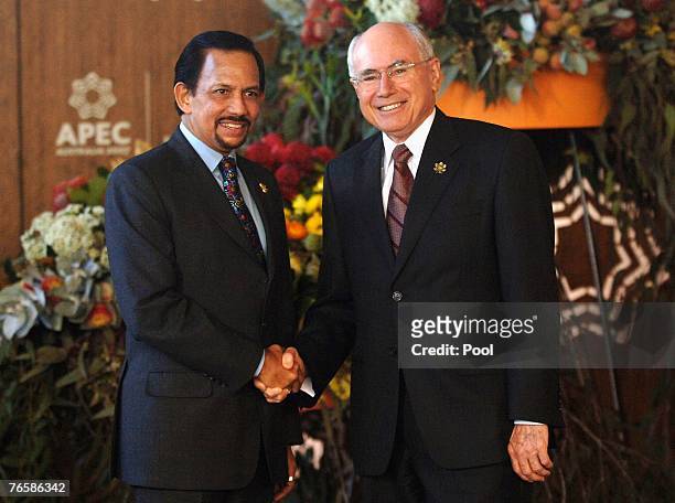 John Howard, Australia's prime minister, greets Hassanal Bolkiah, the sultan of Brunei, ahead of official group dialogue sessions on day seven of the...