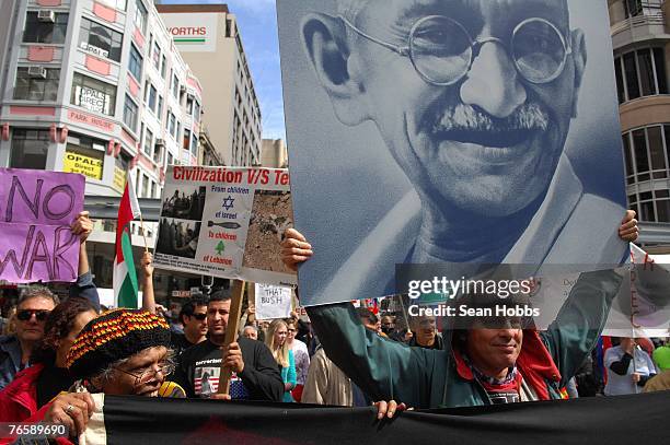 Man carries a placard depicting Gandhi to encourage peaceful protest during the 'Stop Bush - Make Howard History Rally' held at Sydney Town Hall...