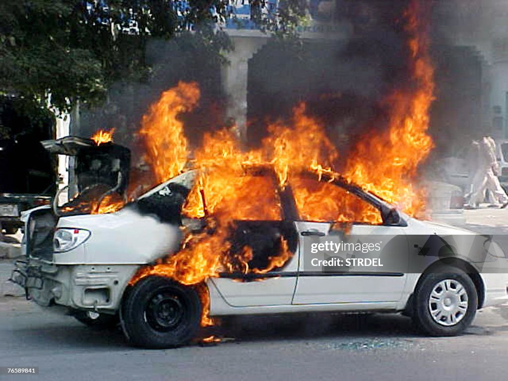 Flames erupt from a burning car after a