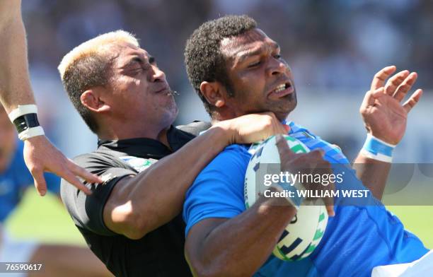 Italy's Manoa Vosawai is tackled by New Zealand's flanker Jerry Collins during their rugby union World Cup 2007 group C match, 08 September 2007 at...