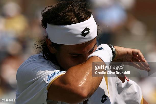 David Ferrer of Spain wipes sweat off of his face against Novak Djokovic of Serbia during day thirteen of the 2007 U.S. Open at the Billie Jean King...
