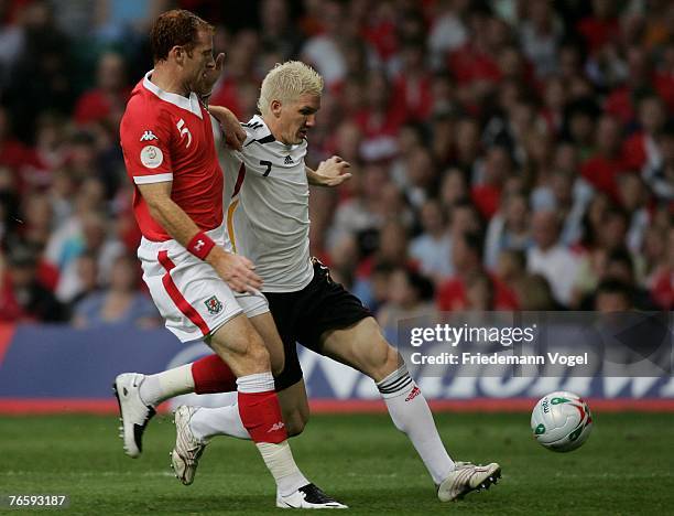 Bastian Schweinsteiger of Germany fights for the ball with James Collins of Wales during the Euro 2008 qualifying match between Wales and Germany at...