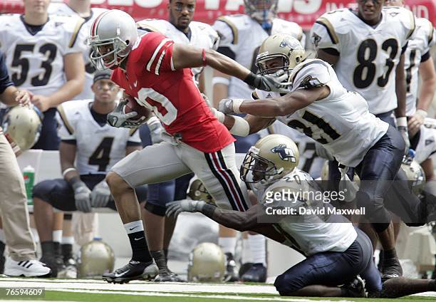 Brian Robiskie of the Ohio State Buckeyes is forced out of bounds by Reggie Corner and Andrew Johnson of the Akron Zips in front of the Akron bench...