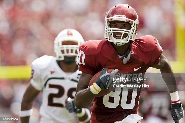 Adron Tennell of the Oklahoma Sooners runs a pass for a touchdown against the Miami Hurricanes at Gaylord Family-Oklahoma Memorial Stadium September...
