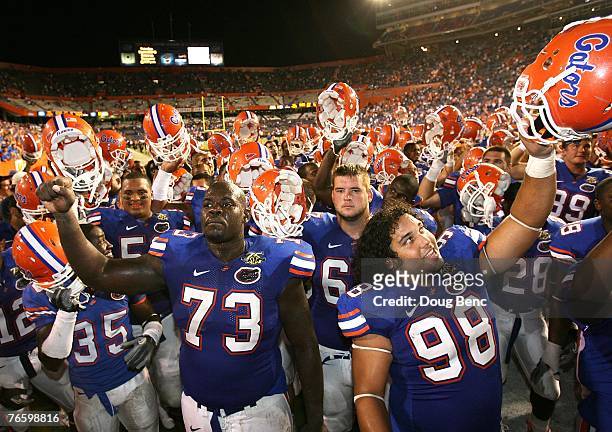 Offensive lineman Carlton Medder and defensive tackle Clint McMillan of the Florida Gators celebrate with fans after defeating the Troy Trojans at...