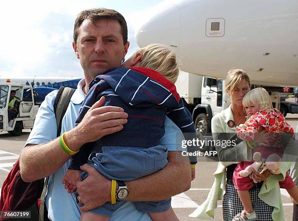 The parents of missing toddler Madeleine McCann, Kate and Gerry carry their two-year-old twin children Sean and Amelie as they arrive back in Britain...