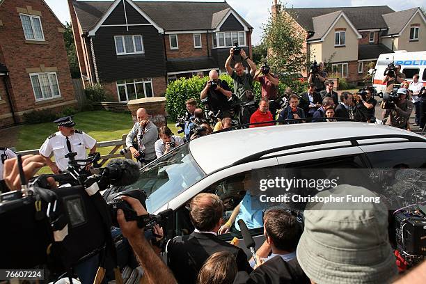 Gerry and Kate McCann drive past the media as they arrive home on September 9, 2007 in Rothley, England. The McCann family have returned from...