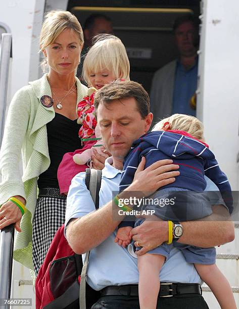 The parents of missing toddler Madeleine McCann, Kate and Gerry carry their two-year-old twin children Sean and Amelie as they arrive back in Britain...