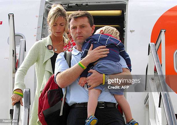 The parents of missing toddler Madeleine McCann, Kate and Gerry carry their two-year-old twin children Sean and Amelie as they arrive back in Britain...