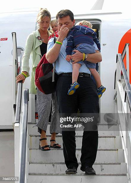 The parents of missing toddler Madeleine McCann, Kate and Gerry carry their two-year-old twin children Sean and Amelie as they arrive back in Britain...