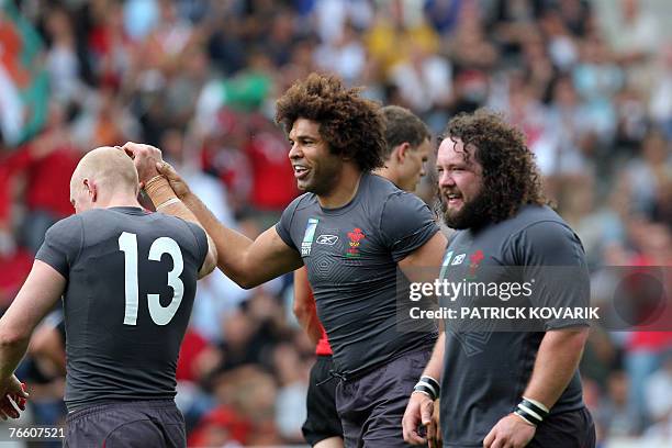 Wales's flanker Colin Charvis jubilates after scoring a try with teammates Wales's centre Tom Shanklin and Wales's prop Adam Jones during the rugby...