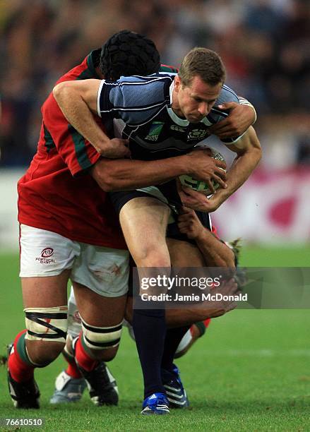 Chris Paterson of Scotland is stopped by Joao Correia and Goncalo Uva of Portugal during match seven of the Rugby World Cup 2007 between Scotland and...