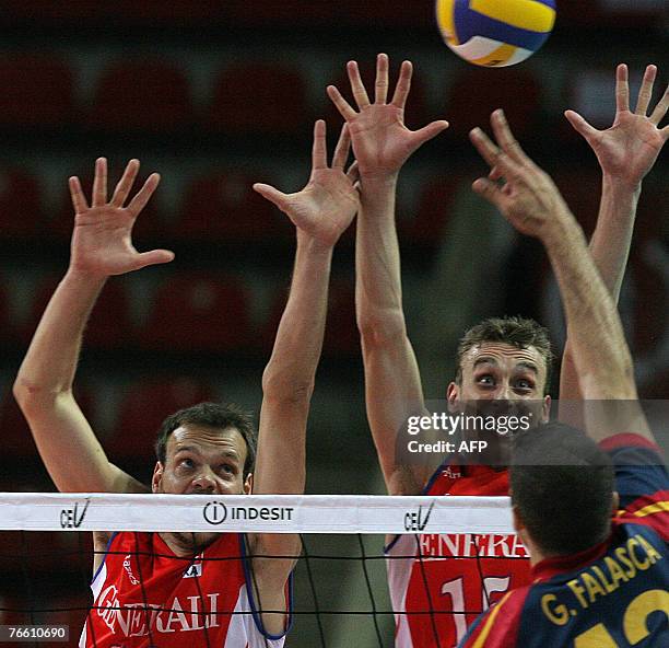 Guillermo Falasca of Spain hits a ball as Vincent Montmeat and Guillaume Samica of France block during their 2007 Men's European Championships...