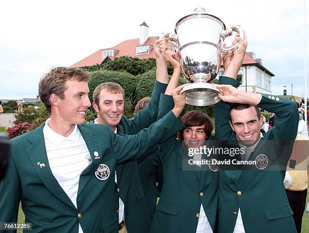 Jamie Lovemark, Dustin Johnson, Rickie Fowler and Billy Horschell pose with the trophy after the United States team had clinched victory during the...