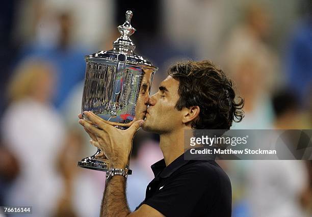 Roger Federer of Switzerland celebrates with the trophy after defeating Novak Djokovic of Serbia by a score of 7-6, 7-6, 6-4 to win the Men's Singles...