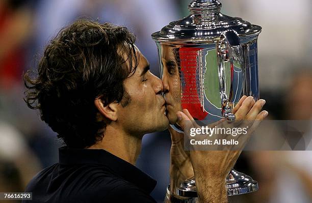 Roger Federer of Switzerland celebrates with the trophy after defeating Novak Djokovic of Serbia by a score of 7-6, 7-6, 6-4 to win the Men's Singles...