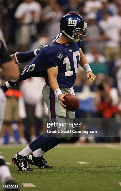 Eli Manning of the New York Giants works to elude a defender against the Dallas Cowboys at Texas Stadium on September 9, 2007 in Dallas Texas.