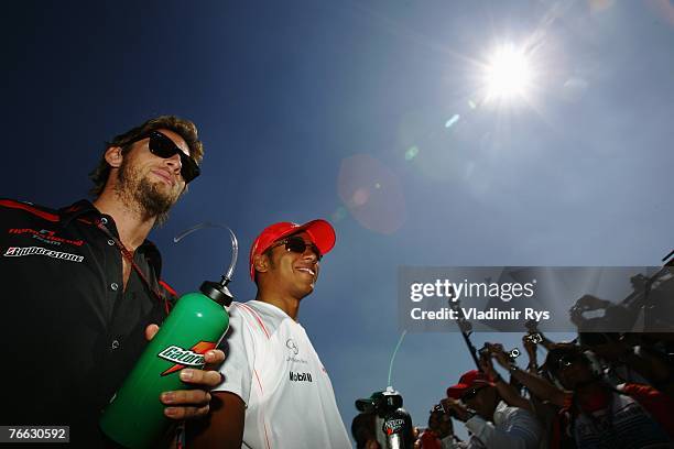 Jenson Button of Great Britain and Honda Racing and Lewis Hamilton of Great Britain and McLaren Mercedes appear at the drivers parade before the...