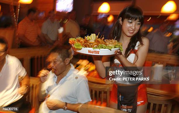 Waitress serves food at the opening of the first Hooters restaurant in Beijing, 10 September 2007. The US restaurant chain famous for its waitresses...