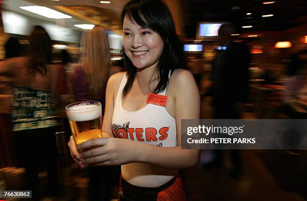 Waitress serves beer at the opening of the first Hooters restaurant in Beijing 10 September 2007. The US restaurant chain famous for its waitresses...