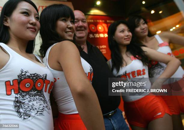 Hooters waitresses pose with customers at the opening of the US restaurant chain's first outlet in Beijing, 10 September 2007, and fourth overall in...