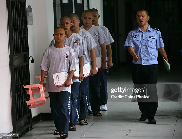 Policeman leads inmates to attend a class at the Chongqing Juvenile Offender Correctional Center September 10, 2007 in Chongqing Municipality, China....