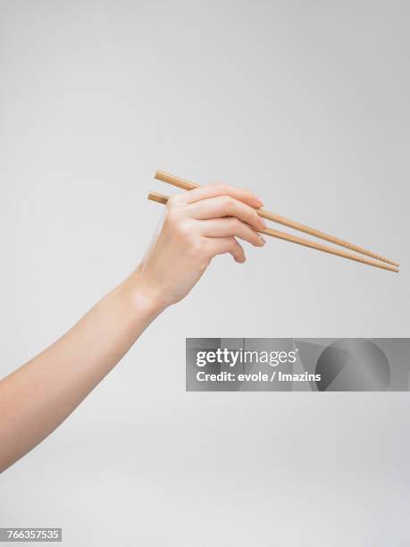 a hand holding a chopstick - korean chopsticks stock pictures, royalty-free photos & images