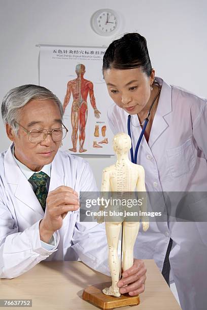 two doctors are examining. - acupuncture elderly stock pictures, royalty-free photos & images