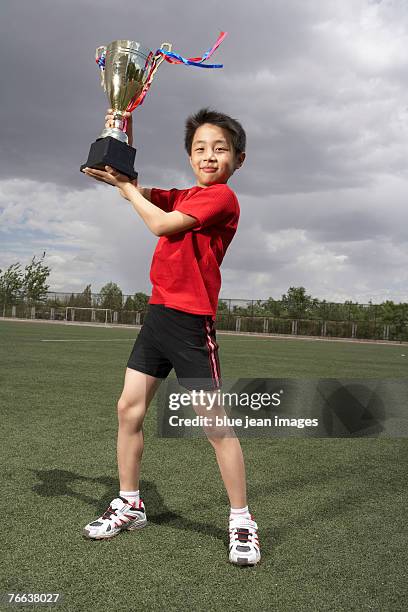 a boy is holding the trophy. - prop sporting position stock pictures, royalty-free photos & images