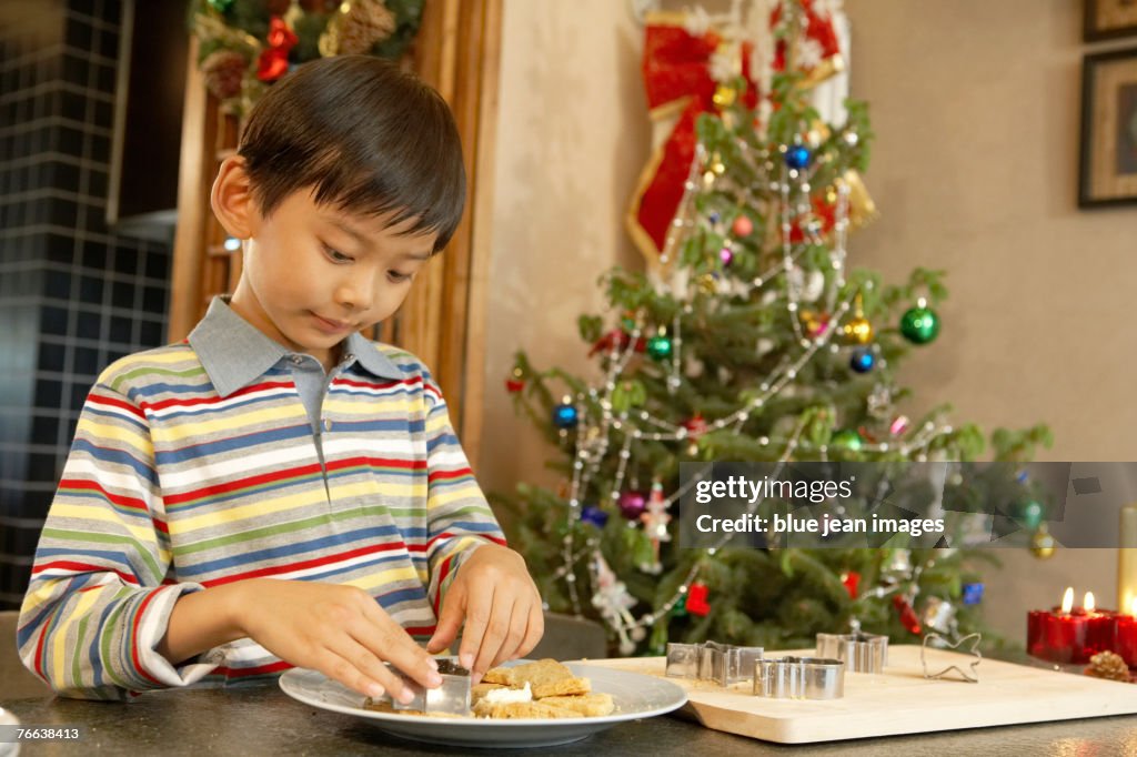 A boy making Christmas cookies.