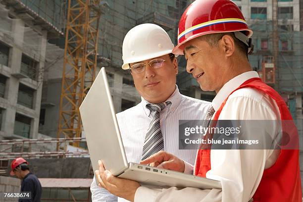 a supervisor and an investor use a computer on a construction site. - falsework stock pictures, royalty-free photos & images