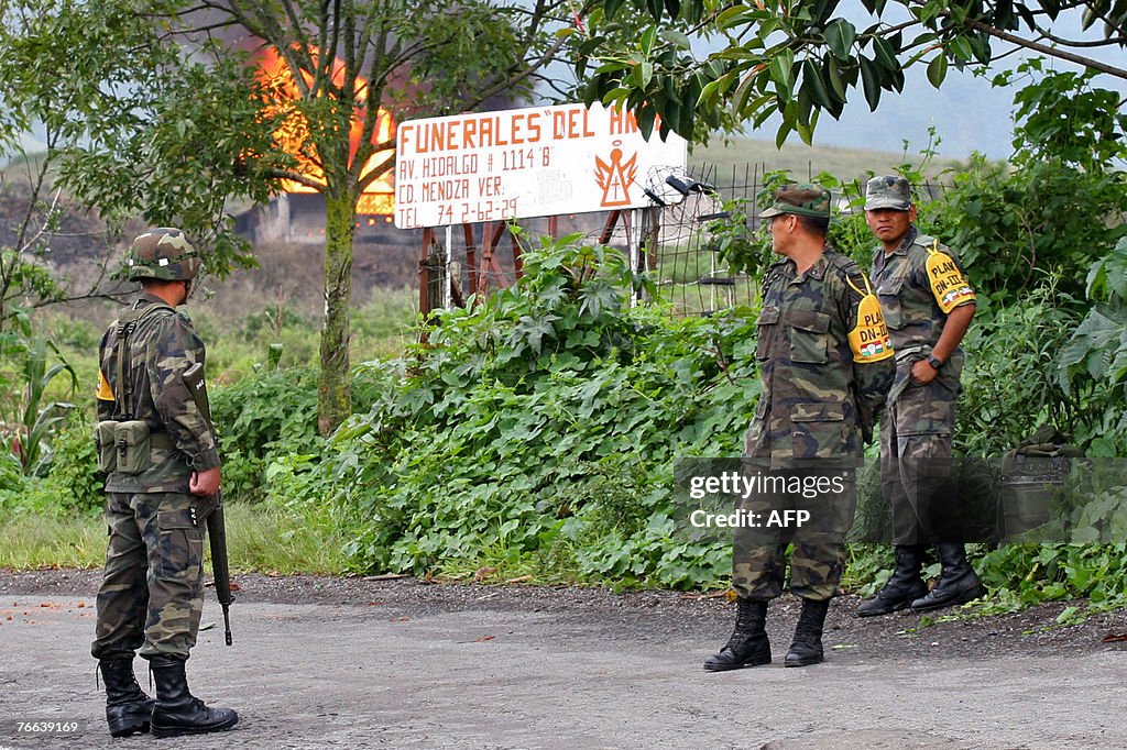 Mexican military personnel stand guard c