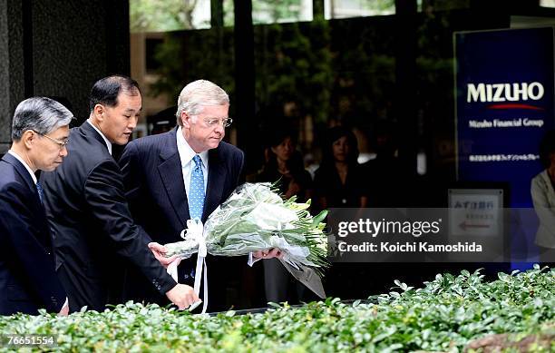 Ambassador to Japan Thomas Schieffer pays his respects and present flowers with Mizuho Financial Group executive President Terunobu Maeda at the the...