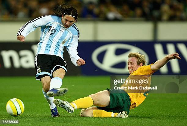 Lionel Messi of Argentina shoots for goal as David Carney of the Socceroos attempts to defend during the international friendly match between the...