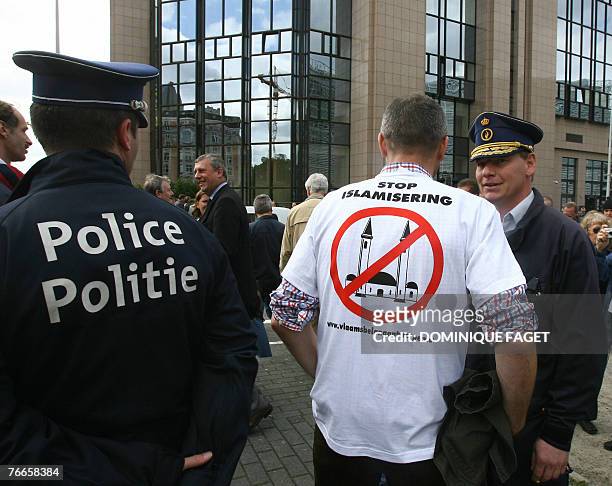 Police officer talks to a supporter of Belglian far-right parties participating in an anti-Islam demonstration held 11 September 2007 in Brussels on...