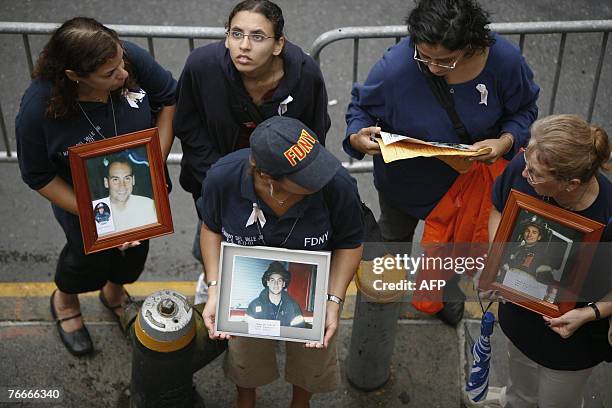 Group of women holding pictures of firefighters, stand 11 September 2007 in front of Engine Co. 10 outside the World Trade Center site during...