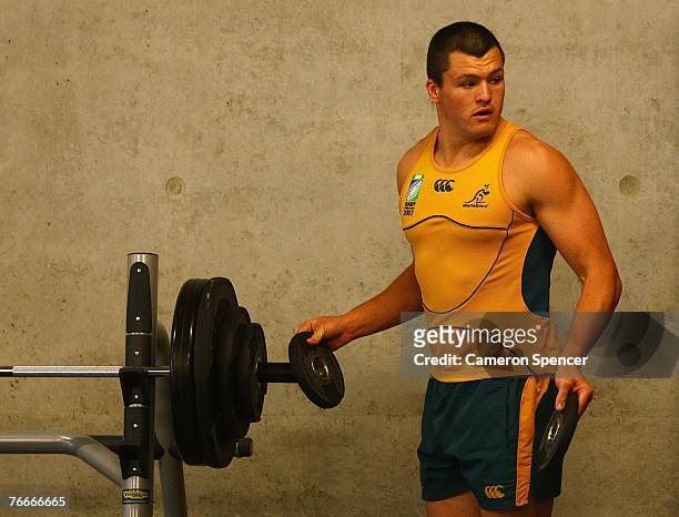 Adam Ashely-Cooper of the Wallabies loads up a barbell during an Australian Wallabies backs strength training session at Stade Yves du Manior...