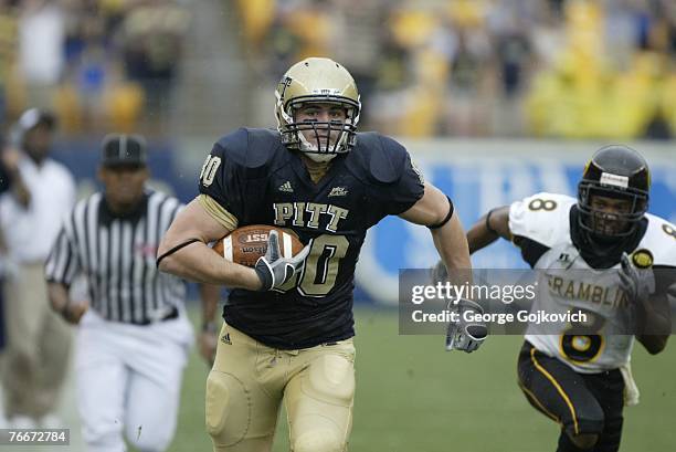 Tight end Nate Byham of the University of Pittsburgh Panthers runs with the football after catching a pass against cornerback Nigel Copeland of the...