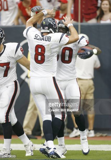 Wide receiver Andre Johnson of the Houston Texans high fives teammate and quarterback Matt Schaub after scoring a touchdown during the game between...