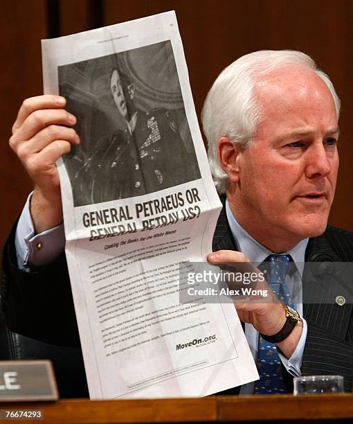 Sen. John Cornyn holds up a copy of an ad paid for by MoveOn.org during a hearing of the Senate Armed Services Committee with General David Petraeus...