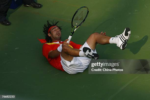 Marcos Baghdatis of Cyprus tumbles as he returns a shot against Boris Pashanski of Serbia during their match on day three of the China Tennis Open on...